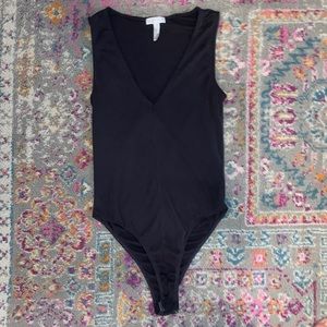 A dark grey body suit with a low cut front.